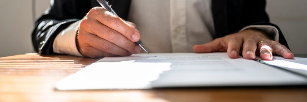 Businessman or a lawyer signing contract, report or legal document