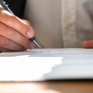 Businessman or a lawyer signing contract, report or legal document